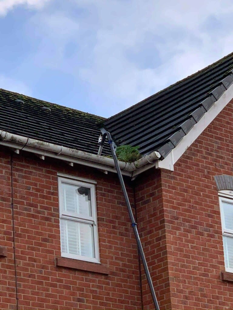 A gutter clean being carried out safely from the ground on a tall building using Pristine Cleans professional gutter vacuum. The built in camera allows the team and the customer to see the results