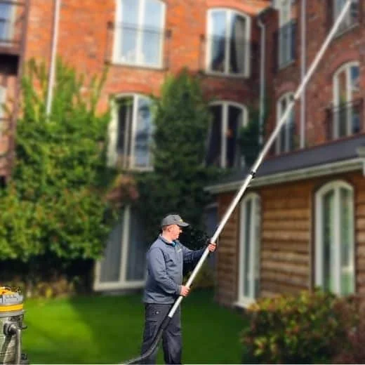 Ibri cleaning windows in Northwich block of flats using the reach and wash method, this method is safe and can be carried out from the floor to reach windows at height.