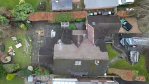 A house in the middle of roof demossing in cheshire. The pristine clean team can be seen using a soft washing warm water technique to clean moss from a roof. The contrast of the one side to the other shows it's progress