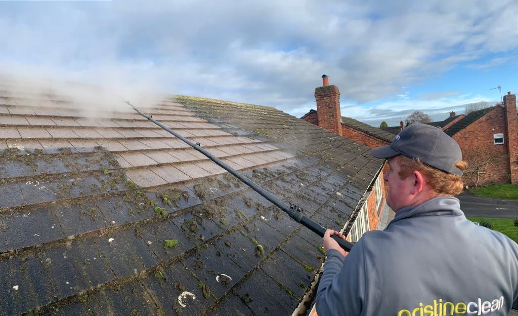 Ibri is out cleaning roofs in cheshire using our soft wash, after only a few minutes the stark contrast between a cleaned and moss less roof is clearly evident.