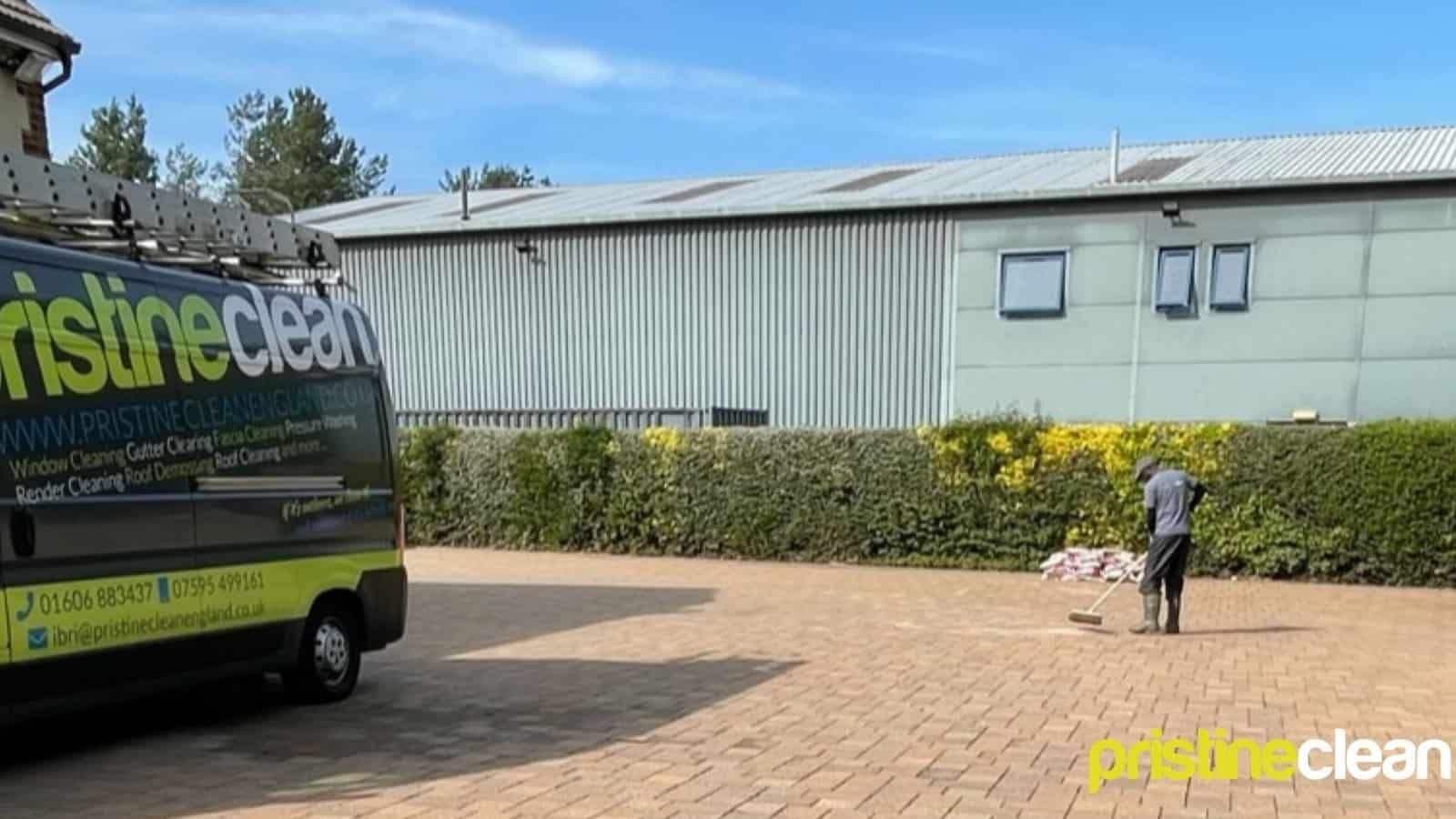 Pristine Clean team member brushing jointing sand into block paving after driveway jet washing in Cheshire to stabilise and protect the surface before winter.