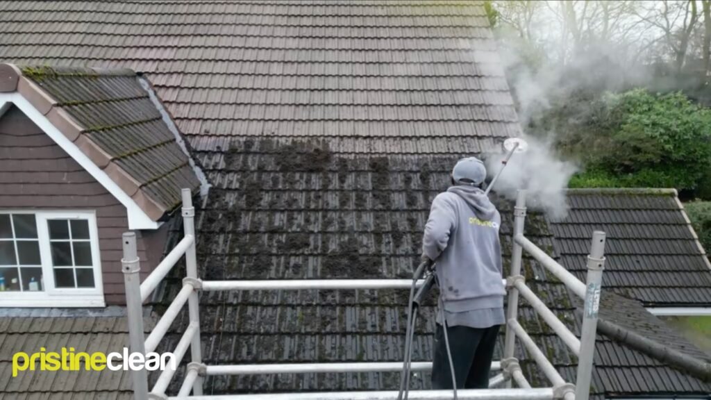 Low pressure steam cleaning removing moss and organic growth from roof tiles.