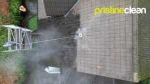 Roof cleaning Cheshire drone view showing half cleaned roof tiles with moss removal in progress from scaffolding platform
