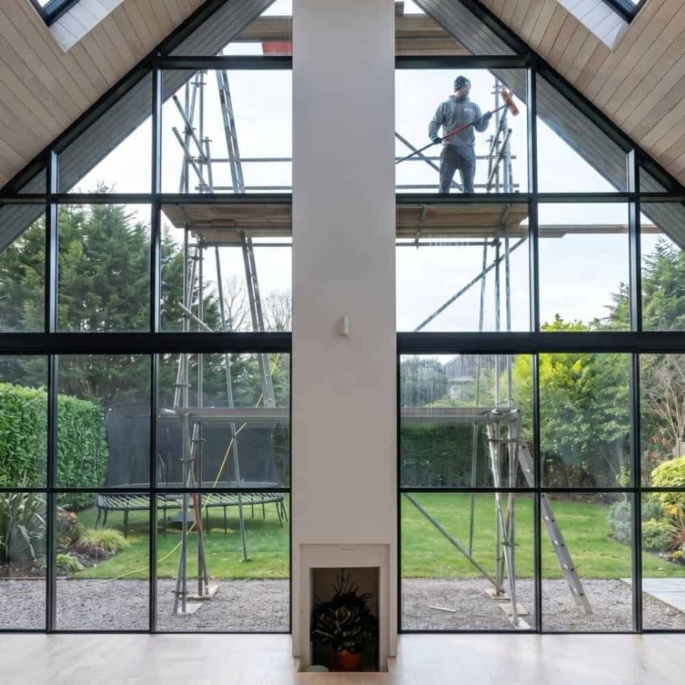 indow cleaner in Cheshire using reach and wash system on large apex windows at a residential property leaving glass spotless