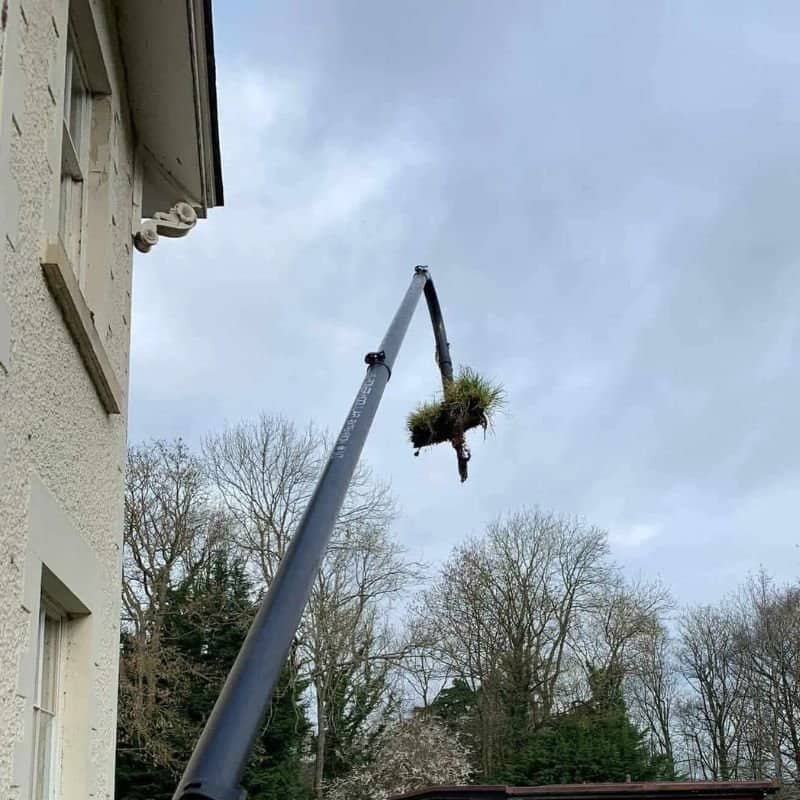 A gutter clearing vacuum removing a huge chunk of mud and grass from and old cheshire buildings gutter system safely at height