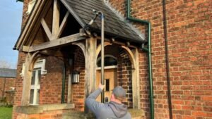 What happens if you don't clean your gutters — Pristine Clean England technician using a gutter vacuum in Cheshire